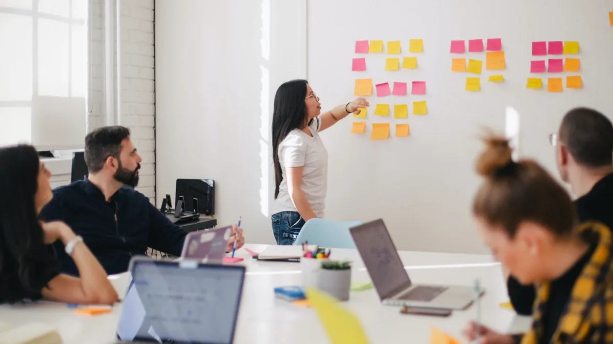 A facilitator presenting a planning session on a whiteboard to a workplace team